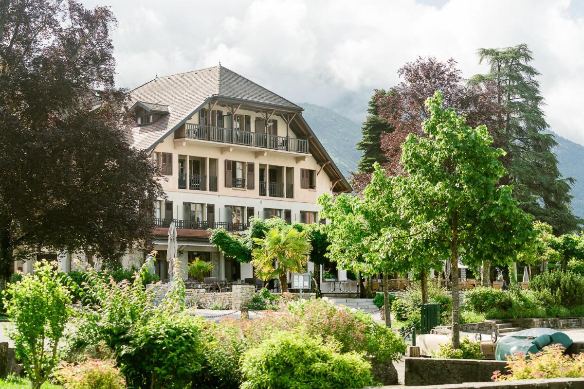 une grande maison avec un jardin devant dans l'établissement Hotel Le Cottage Bise, à Talloires
