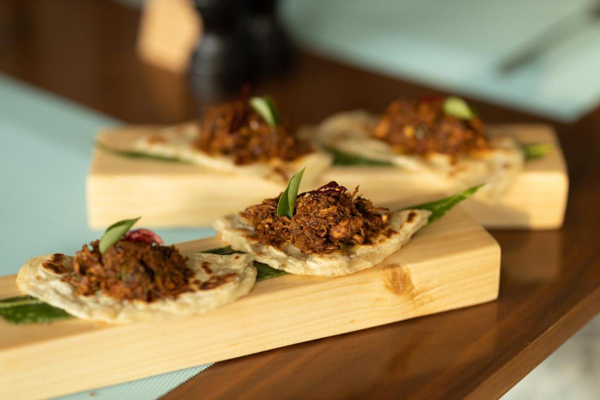 three pieces of food on a wooden cutting board at Holiday Inn Goa Candolim in Candolim three pieces of food on a wooden cutting board at Holiday Inn Goa Candolim in Candolim