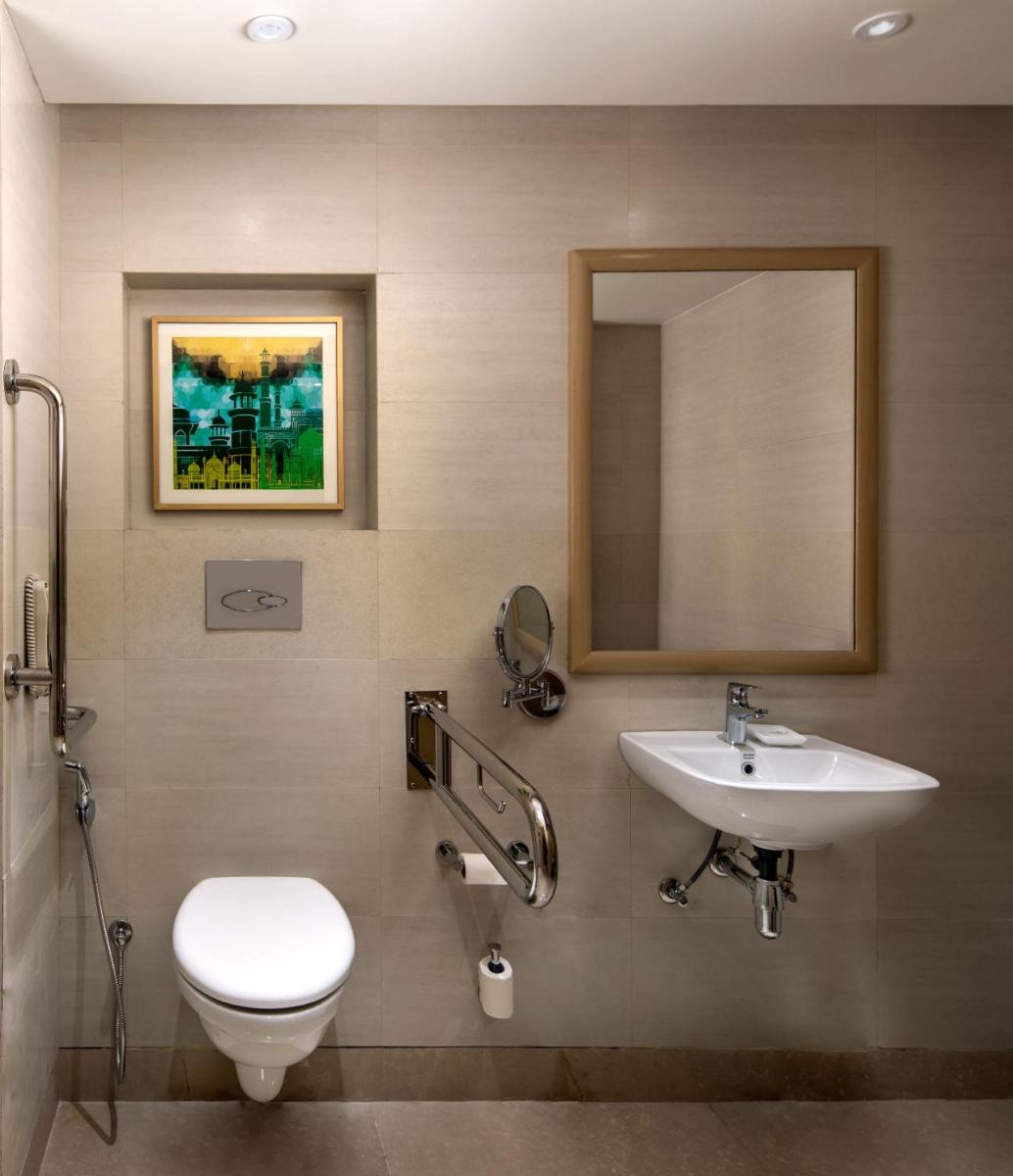 a bathroom with a toilet and a sink and a mirror at Holiday Inn Agra MG Road an IHG Hotel in Agra