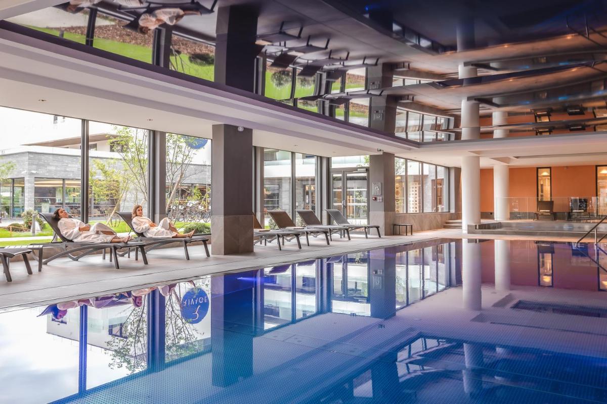 - une piscine dans un bâtiment avec des chaises dans l'établissement Rivage Hôtel & Spa Annecy, à Annecy