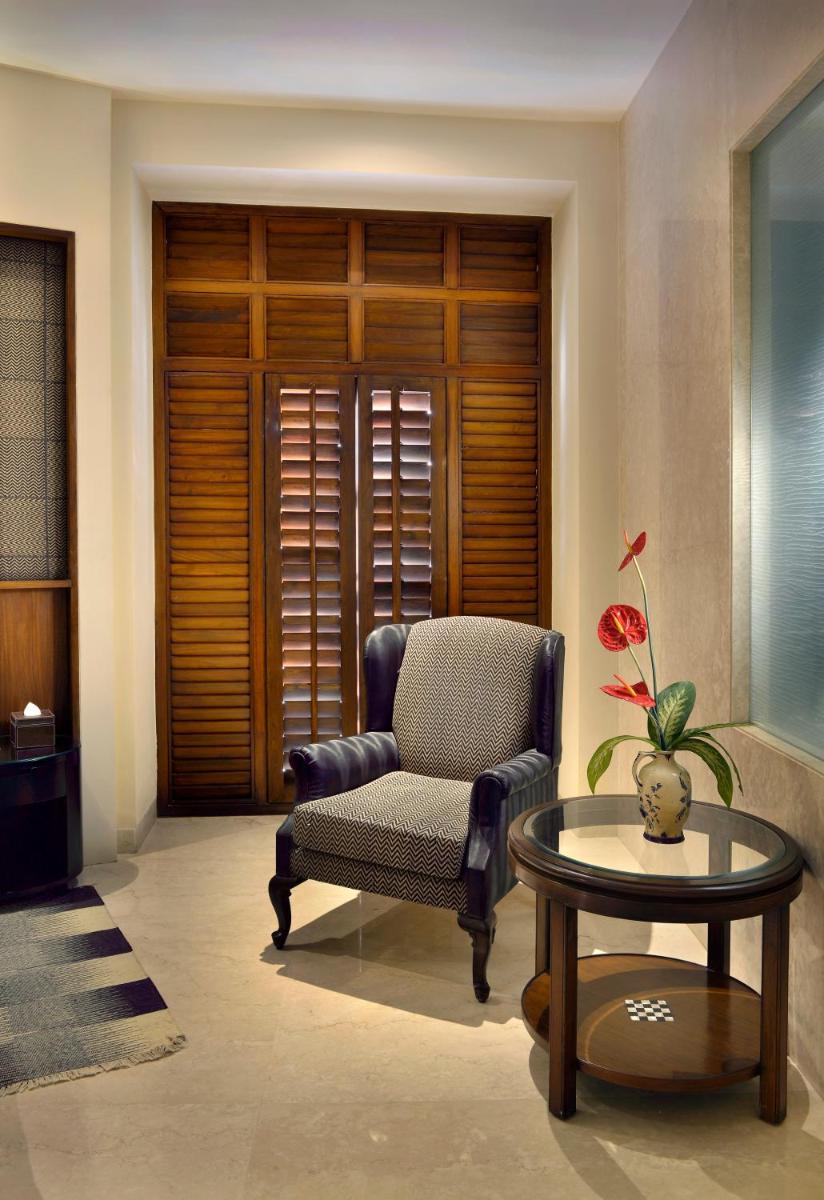 a living room with a chair and a table at The Lalit Great Eastern Kolkata in Kolkata a living room with a chair and a table at The Lalit Great Eastern Kolkata in Kolkata