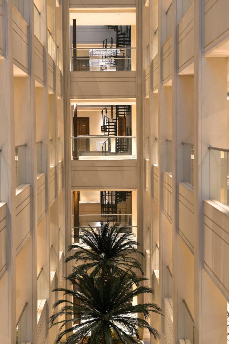 a tall building with a palm tree in front of it at The Lalit Great Eastern Kolkata in Kolkata a tall building with a palm tree in front of it at The Lalit Great Eastern Kolkata in Kolkata