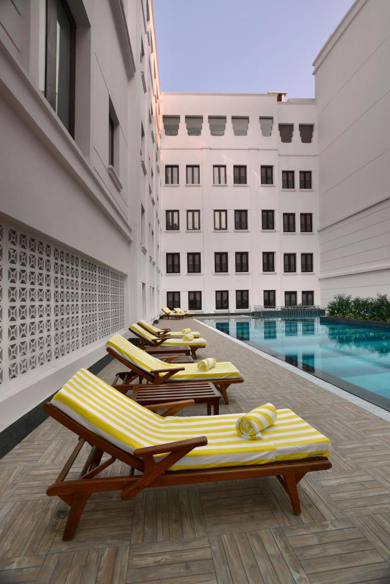 a row of chaise lounges in a hotel pool at The Lalit Great Eastern Kolkata in Kolkata a row of chaise lounges in a hotel pool at The Lalit Great Eastern Kolkata in Kolkata