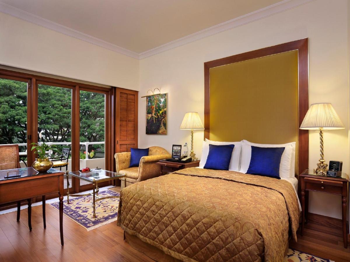 a bedroom with a bed and a desk and a couch at The Oberoi Bengaluru in Bengaluru a bedroom with a bed and a desk and a couch at The Oberoi Bengaluru in Bengaluru