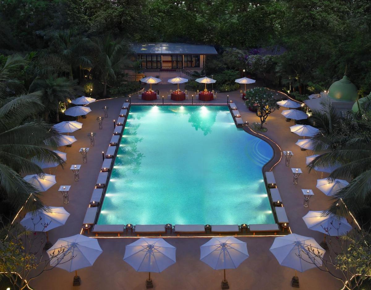 an overhead view of a swimming pool with umbrellas at The Leela Palace Bengaluru in Bengaluru an overhead view of a swimming pool with umbrellas at The Leela Palace Bengaluru in Bengaluru