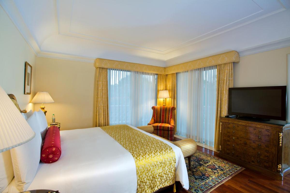 a hotel room with a bed and a flat screen tv at The Leela Palace Bengaluru in Bengaluru a hotel room with a bed and a flat screen tv at The Leela Palace Bengaluru in Bengaluru