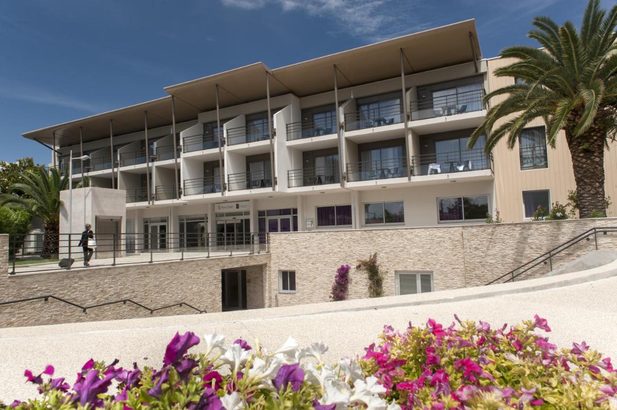 un bâtiment avec des fleurs devant lui dans l'établissement Thalazur Antibes - Résidence & Spa, à Antibes