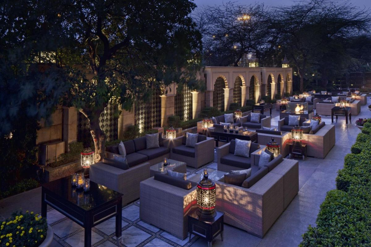 a patio with couches and tables and lights at The Leela Palace New Delhi in New Delhi a patio with couches and tables and lights at The Leela Palace New Delhi in New Delhi