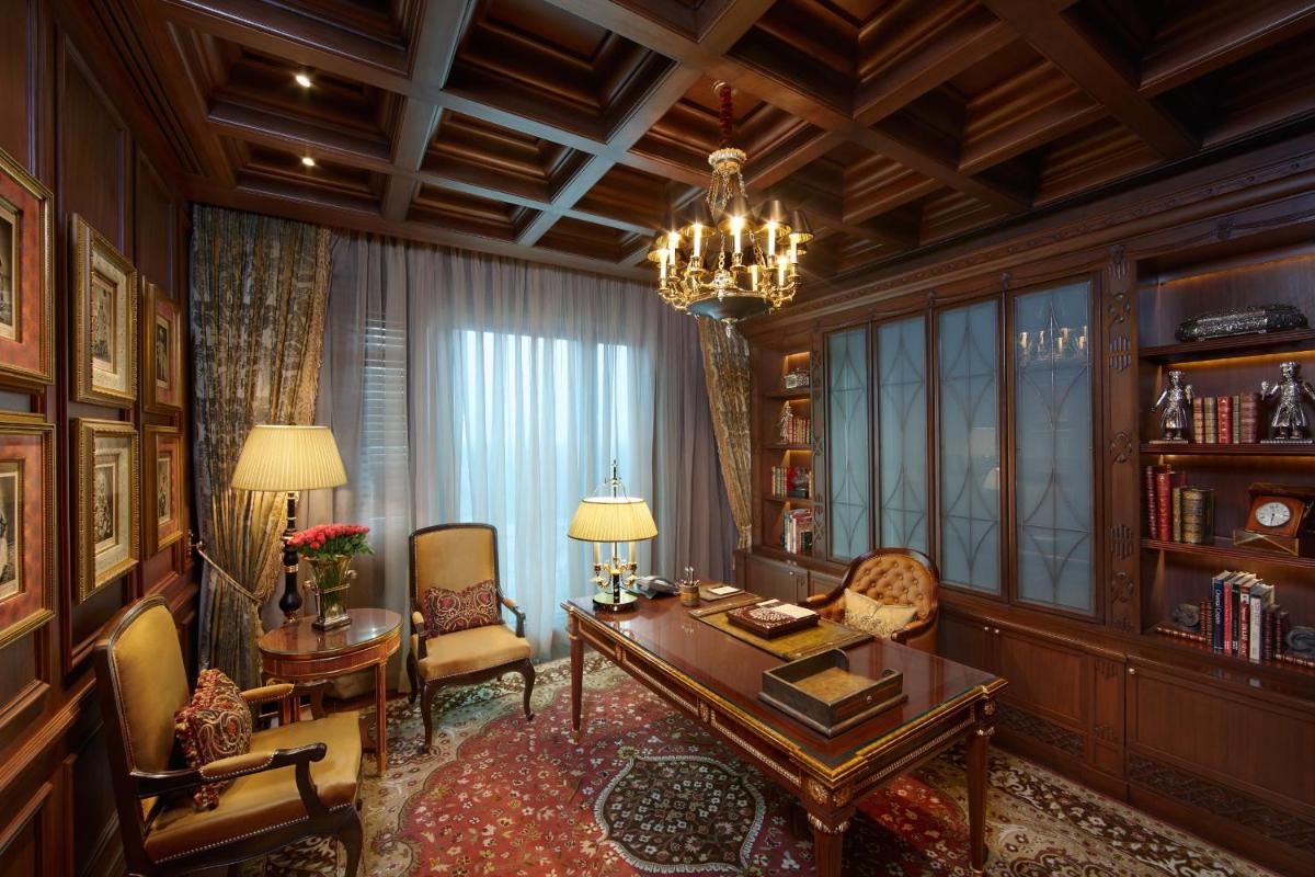 a living room with a table and chairs and a chandelier at The Leela Palace New Delhi in New Delhi a living room with a table and chairs and a chandelier at The Leela Palace New Delhi in New Delhi