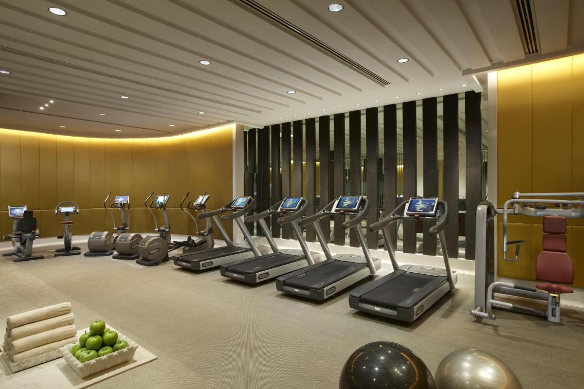 a gym with a row of treadmills and ellipticals at The Leela Palace New Delhi in New Delhi a gym with a row of treadmills and ellipticals at The Leela Palace New Delhi in New Delhi