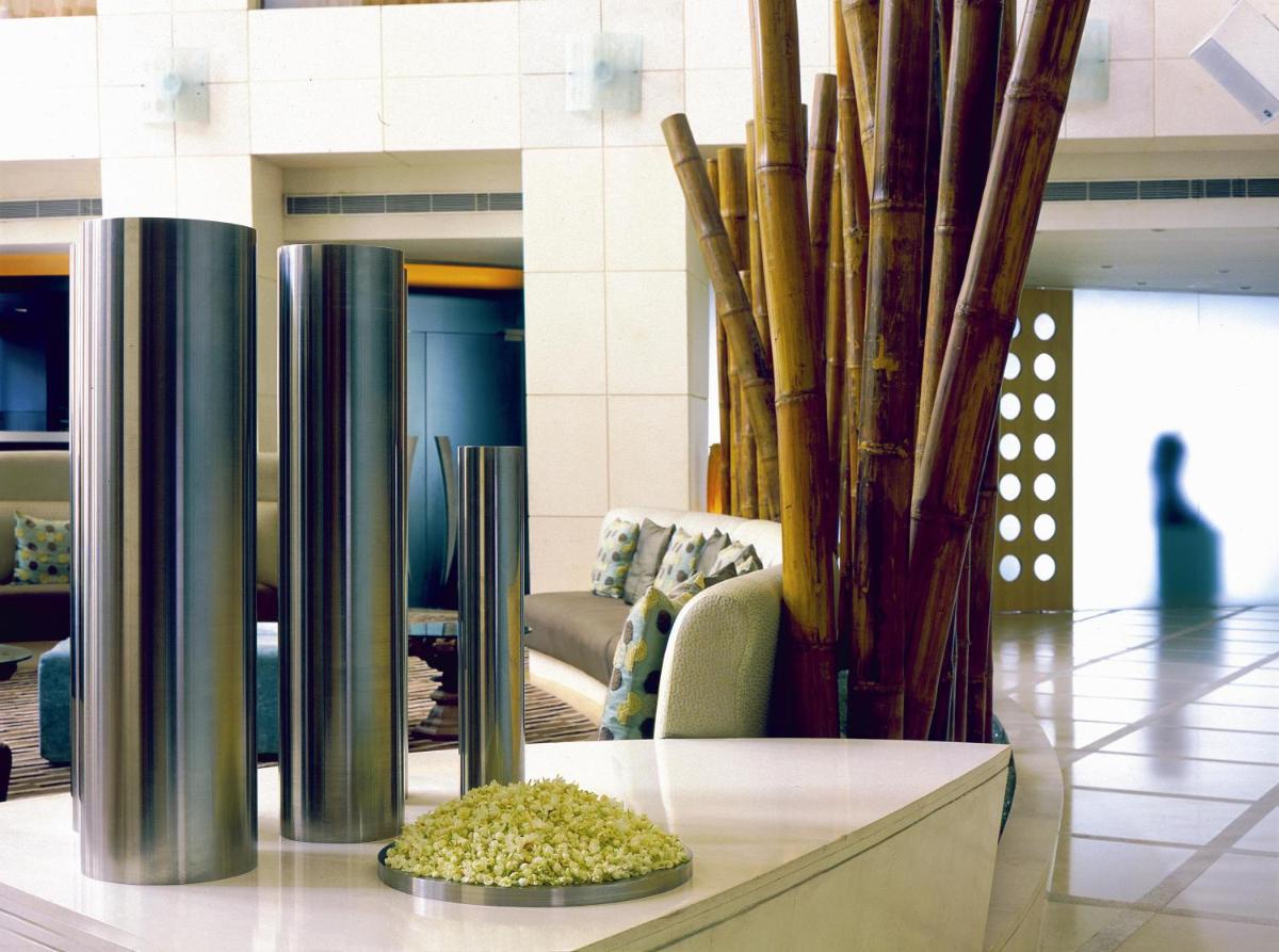 a lobby with a couch and some bamboo poles at The Park Chennai in Chennai a lobby with a couch and some bamboo poles at The Park Chennai in Chennai