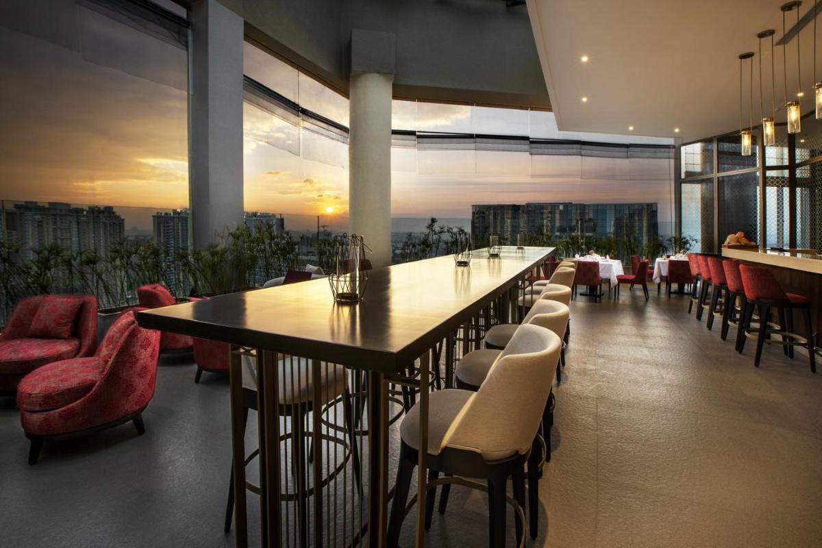 a dining room with a long table and chairs at The Leela Bhartiya City Bengaluru in Bengaluru a dining room with a long table and chairs at The Leela Bhartiya City Bengaluru in Bengaluru