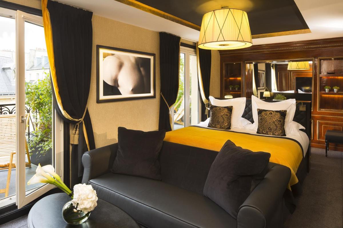 une chambre d'hôtel avec un lit et un canapé dans l'établissement Le Belmont Paris, à Paris