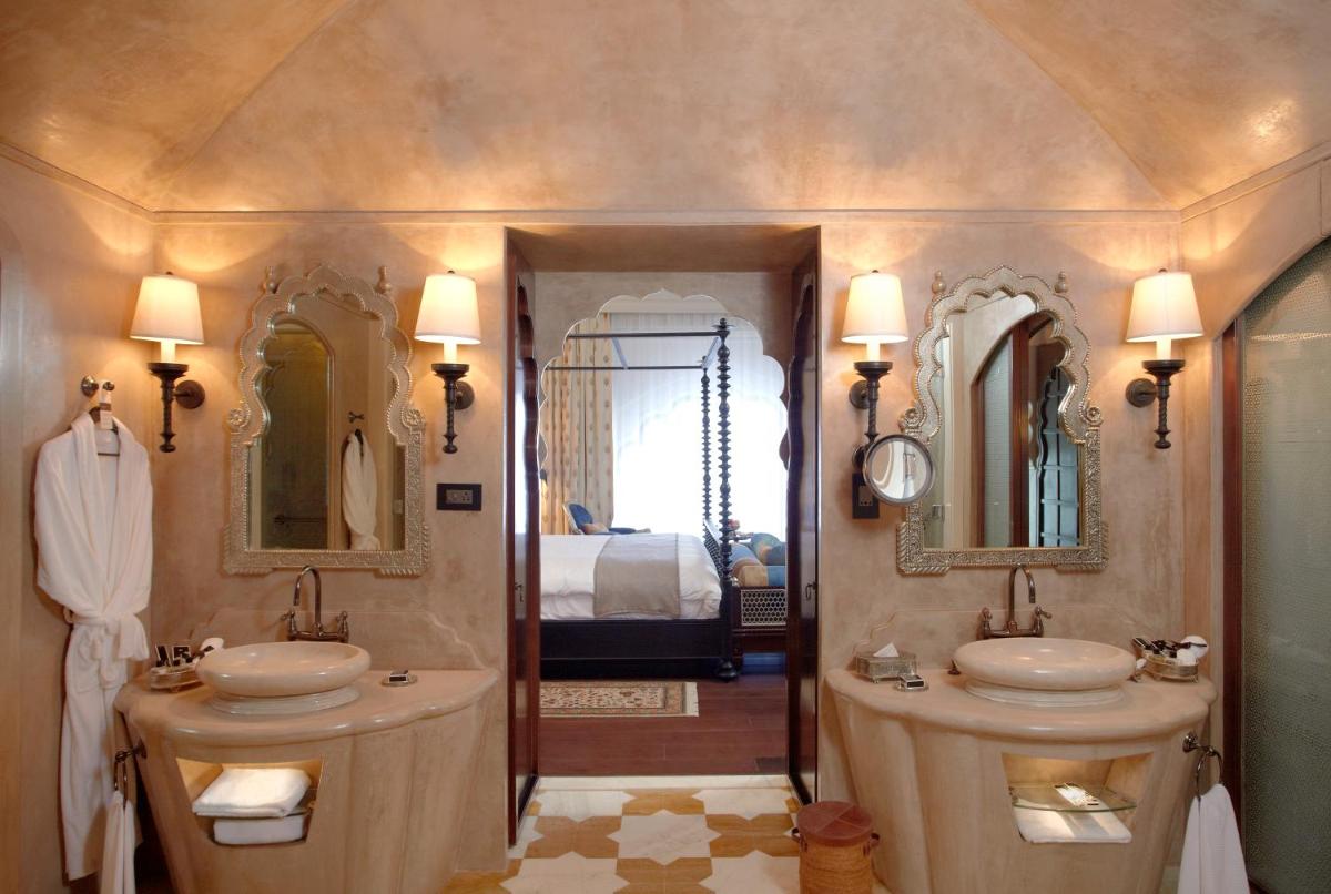 a bathroom with two sinks and two mirrors at Fairmont Jaipur in Jaipur