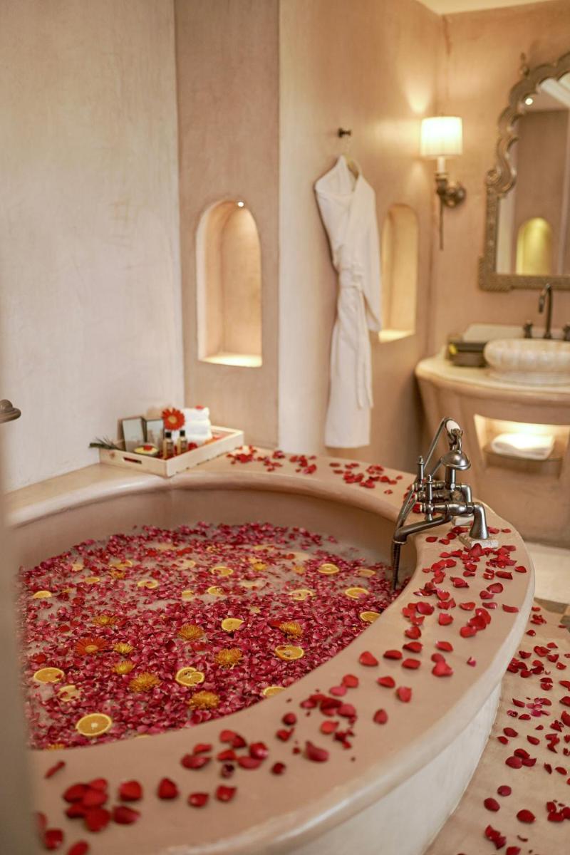 a bathroom with a large tub full of flowers at Fairmont Jaipur in Jaipur