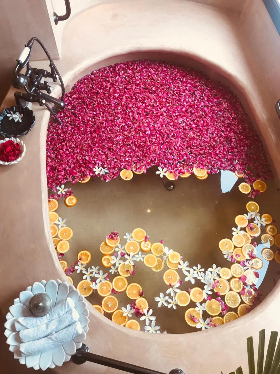 a large pot filled with pink flowers in the water at Fairmont Jaipur in Jaipur