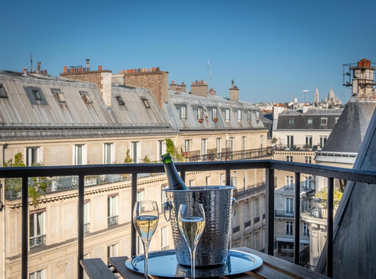 - une bouteille de champagne et deux verres sur un balcon dans l'établissement Hotel Litteraire Le Swann, BW Premier Collection, à Paris