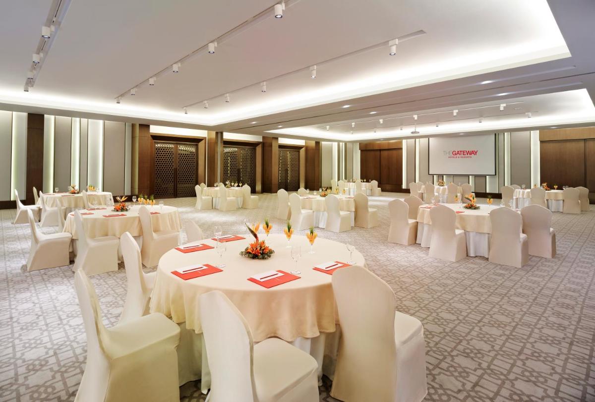 a banquet hall with white tables and white chairs at Vivanta Chennai IT Expressway OMR in Chennai +28 photos