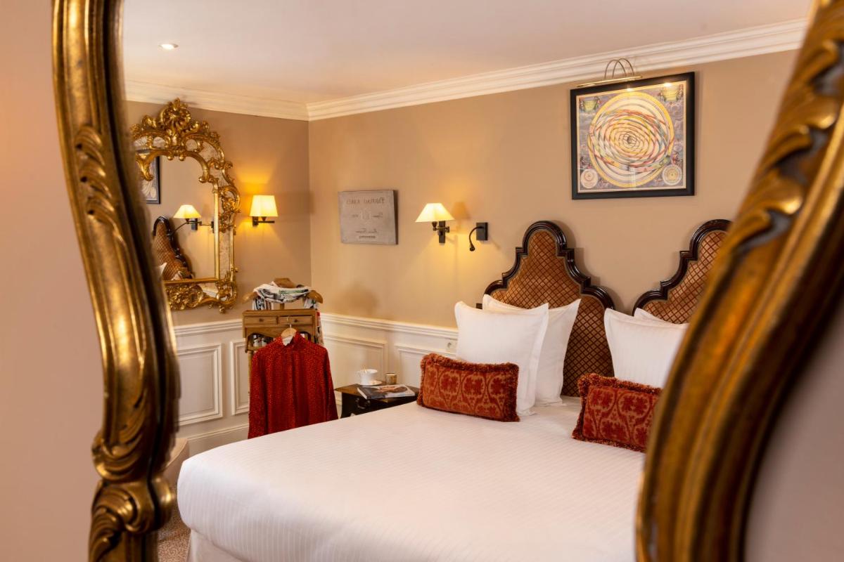 une chambre d'hôtel avec deux lits et un miroir dans l'établissement Ermitage - Mont-Saint-Michel, à Beauvoir