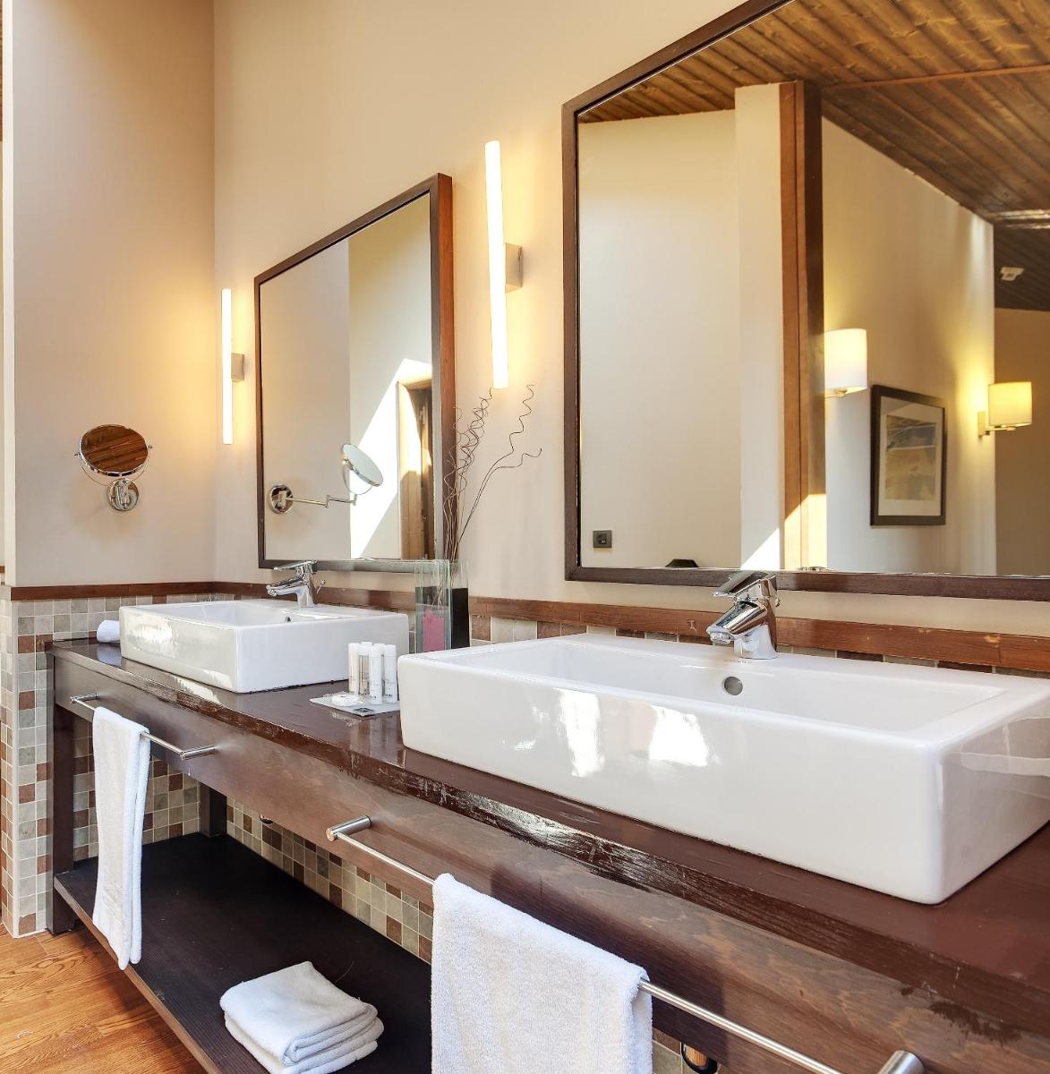 Un baño con dos lavabos y un espejo grande. en Hotel & Spa Real Badaguás Jaca, en Badaguás 42 fotos más