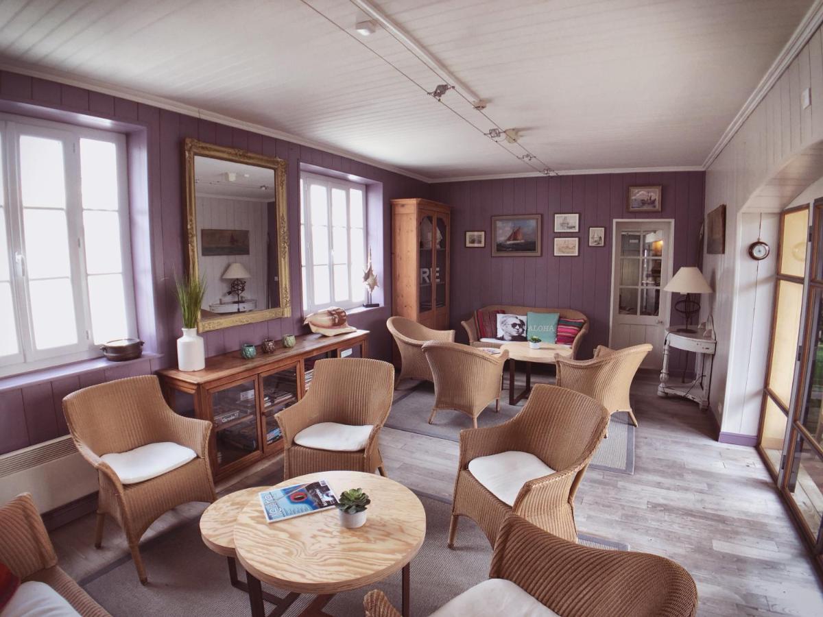 - une salle d'attente avec des chaises, des tables et un miroir dans l'établissement Hotel L'Océan, au Bois-Plage-en-Ré
