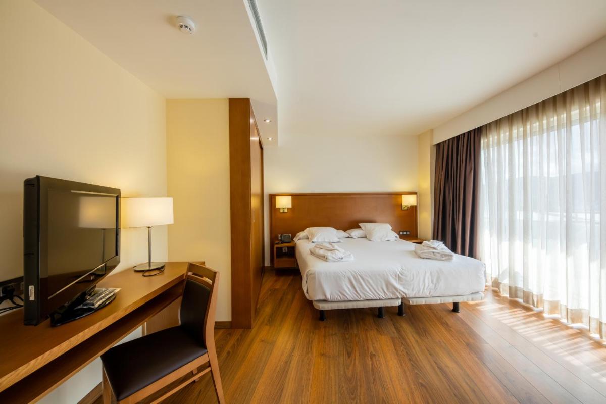 una habitación de hotel con una cama y un televisor en Hotel Thalasso Cantabrico Las Sirenas 4 Superior, en Viveiro