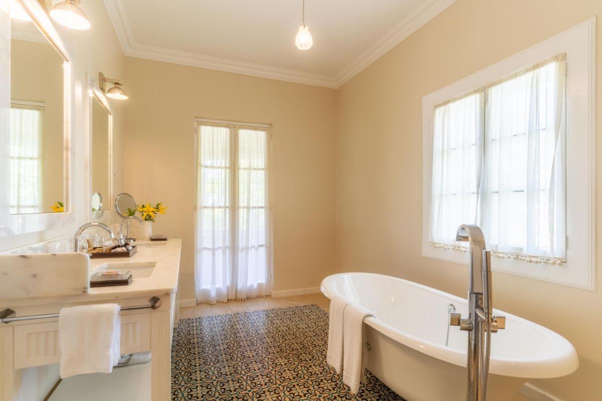 um banheiro com banheira e pia em Quinta da Casa Branca - Small Luxury Hotels of the World no Funchal