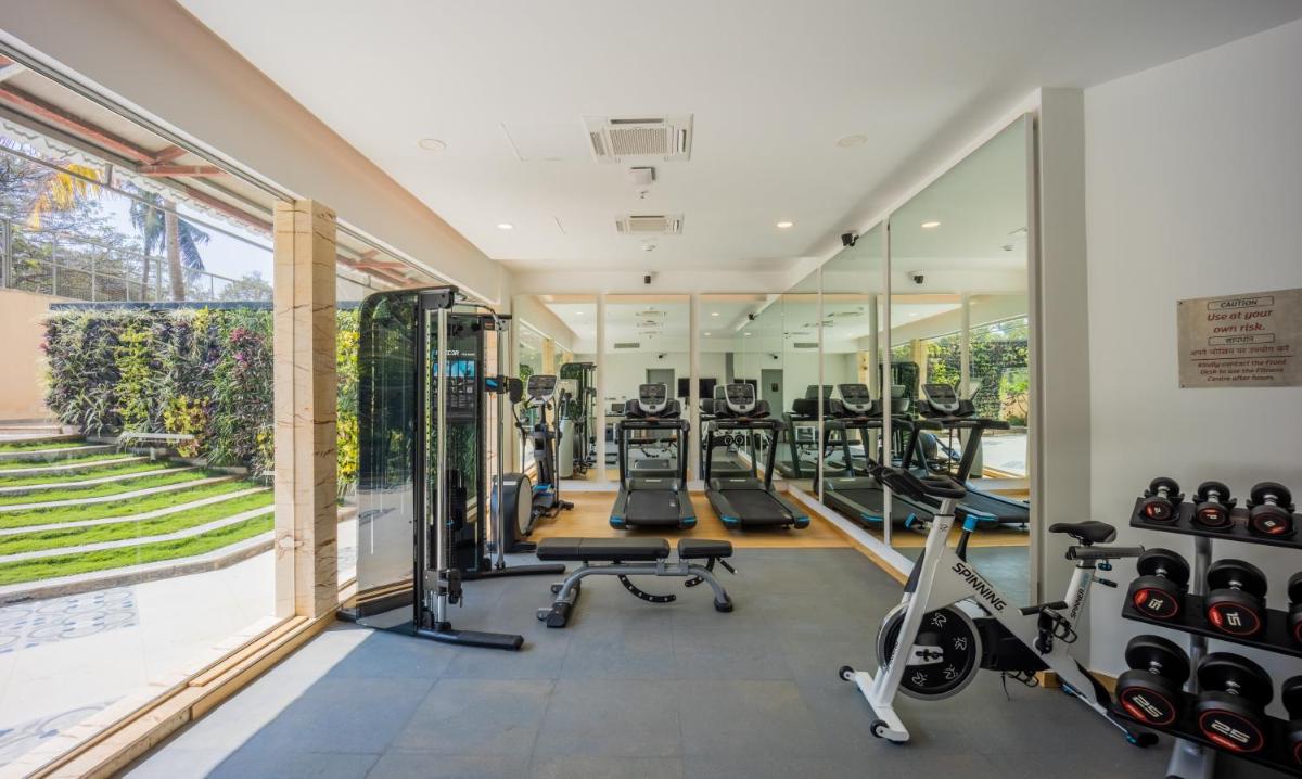 an image of a gym with mirrors and treadmills at Holiday Inn Goa Candolim in Candolim an image of a gym with mirrors and treadmills at Holiday Inn Goa Candolim in Candolim