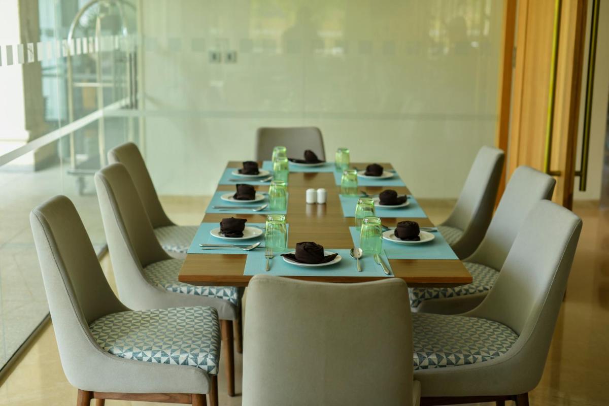 a conference room with a table and chairs with food on it at Holiday Inn Goa Candolim in Candolim a conference room with a table and chairs with food on it at Holiday Inn Goa Candolim in Candolim