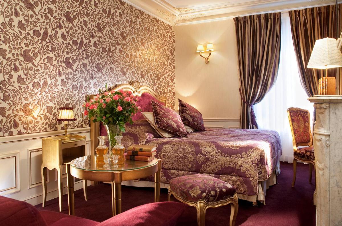 une chambre d'hôtel avec un lit et une table avec des fleurs dans l'établissement Hotel & Spa Saint-Jacques, à Paris