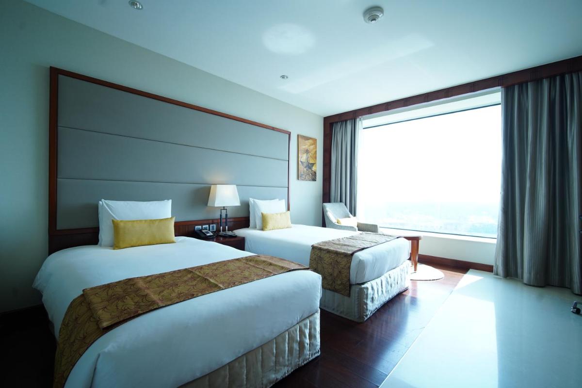a hotel room with two beds and a large window at Crowne Plaza Kochi by IHG in Cochin