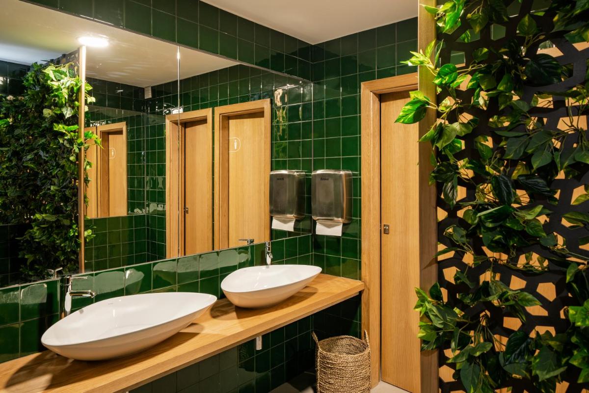 uma casa de banho com 2 lavatórios e uma parede em azulejo verde em Dorisol Buganvilia Studio Hotel no Funchal