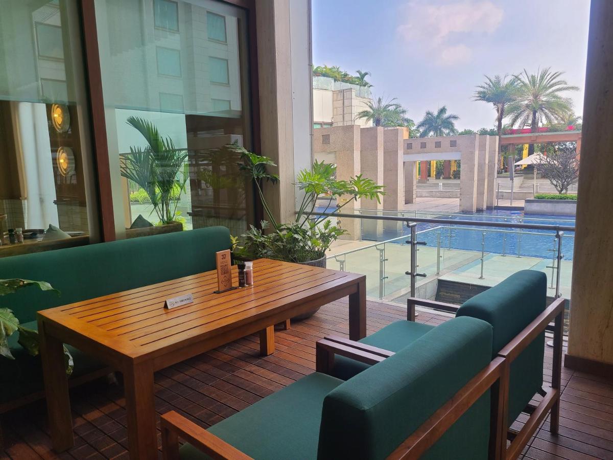 a restaurant with a table and chairs and a large window at Novotel Hyderabad Airport in Hyderabad