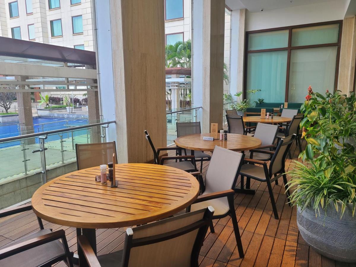 a row of tables and chairs on a balcony at Novotel Hyderabad Airport in Hyderabad