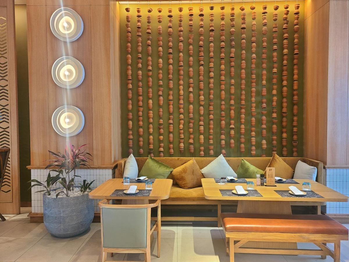 a restaurant with two tables and a couch at Novotel Hyderabad Airport in Hyderabad