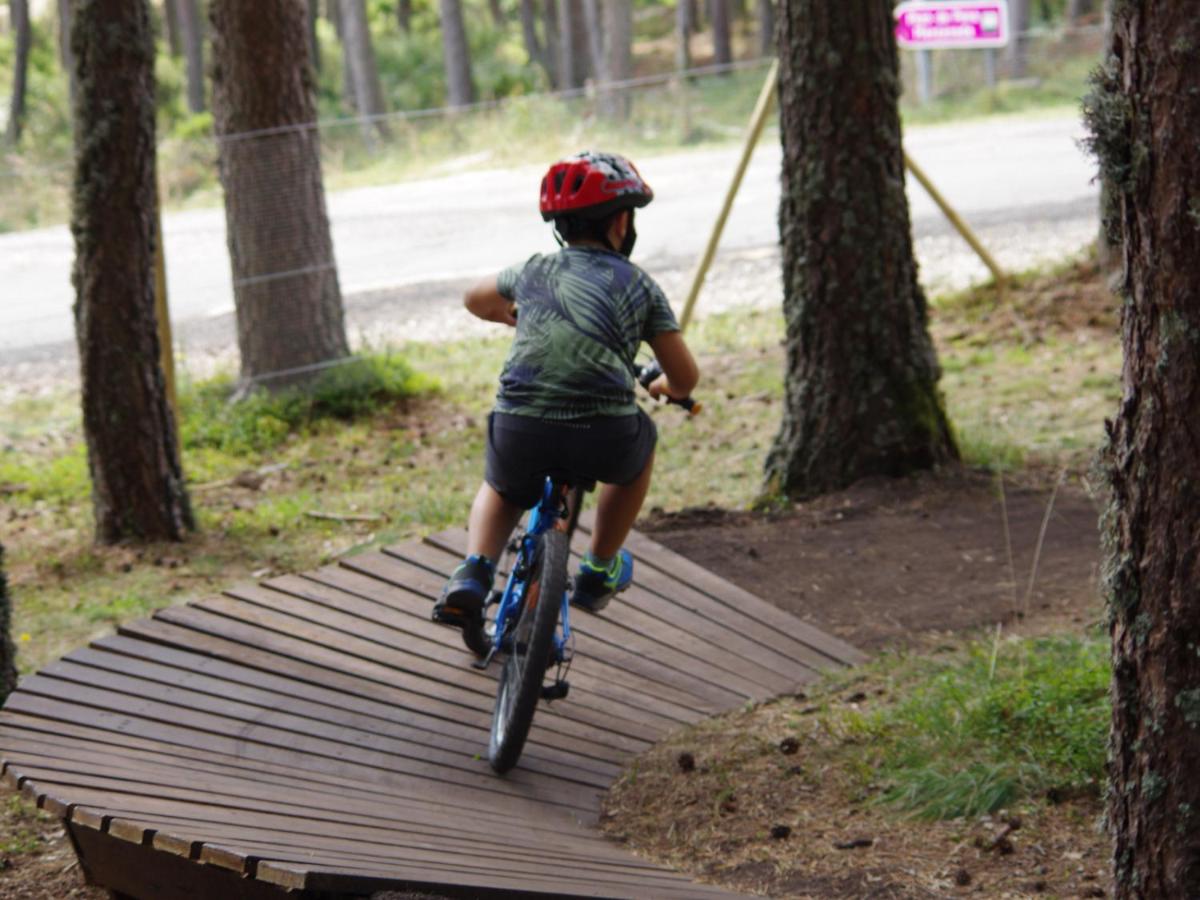 un niño pequeño montando una bicicleta en un paseo marítimo de madera en Estación de Montaña Manzaneda, en Puebla de Trives 53 fotos más