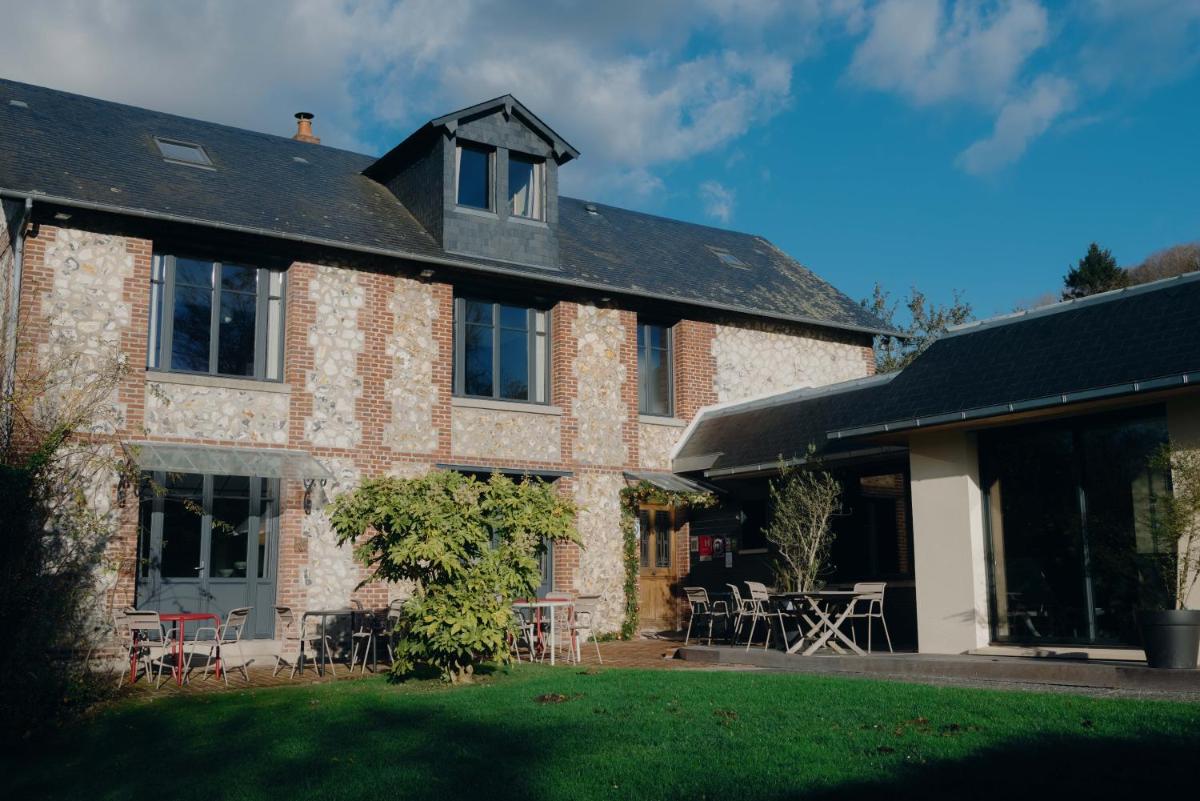 une grande maison en briques avec des tables et des chaises dans la cour dans l'établissement La Fraîchette-Hôtel & Spa, à Honfleur