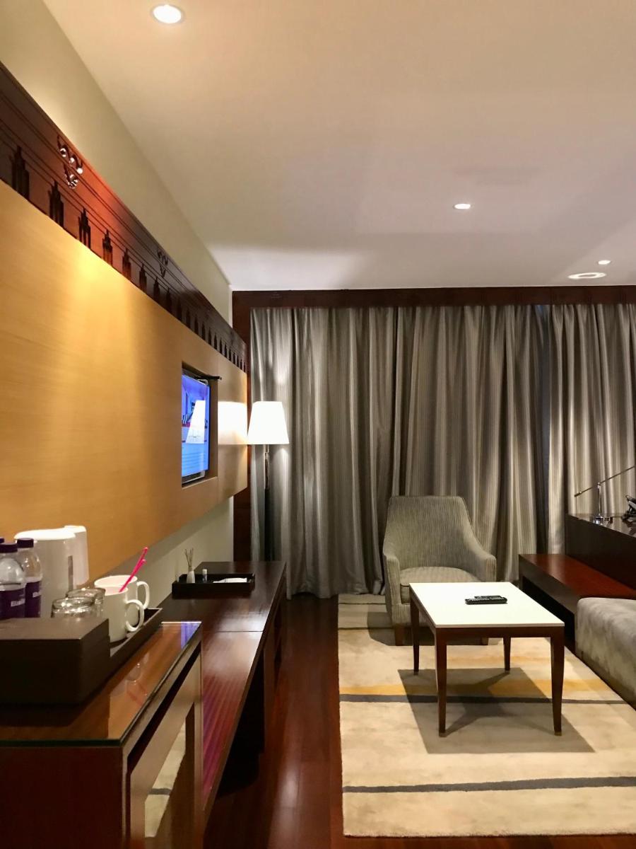 a living room with a couch and a table at Crowne Plaza Kochi by IHG in Cochin