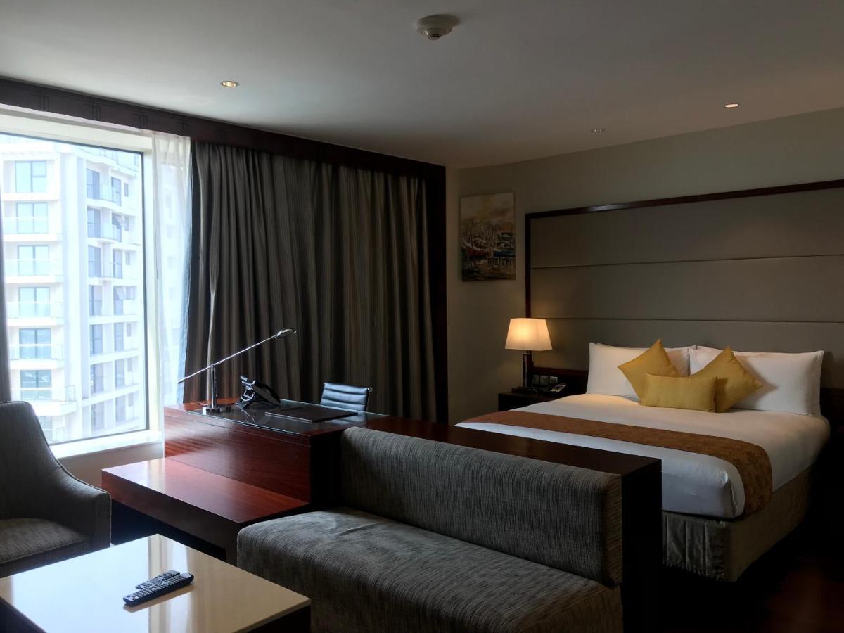 a hotel room with a bed and a couch at Crowne Plaza Kochi by IHG in Cochin