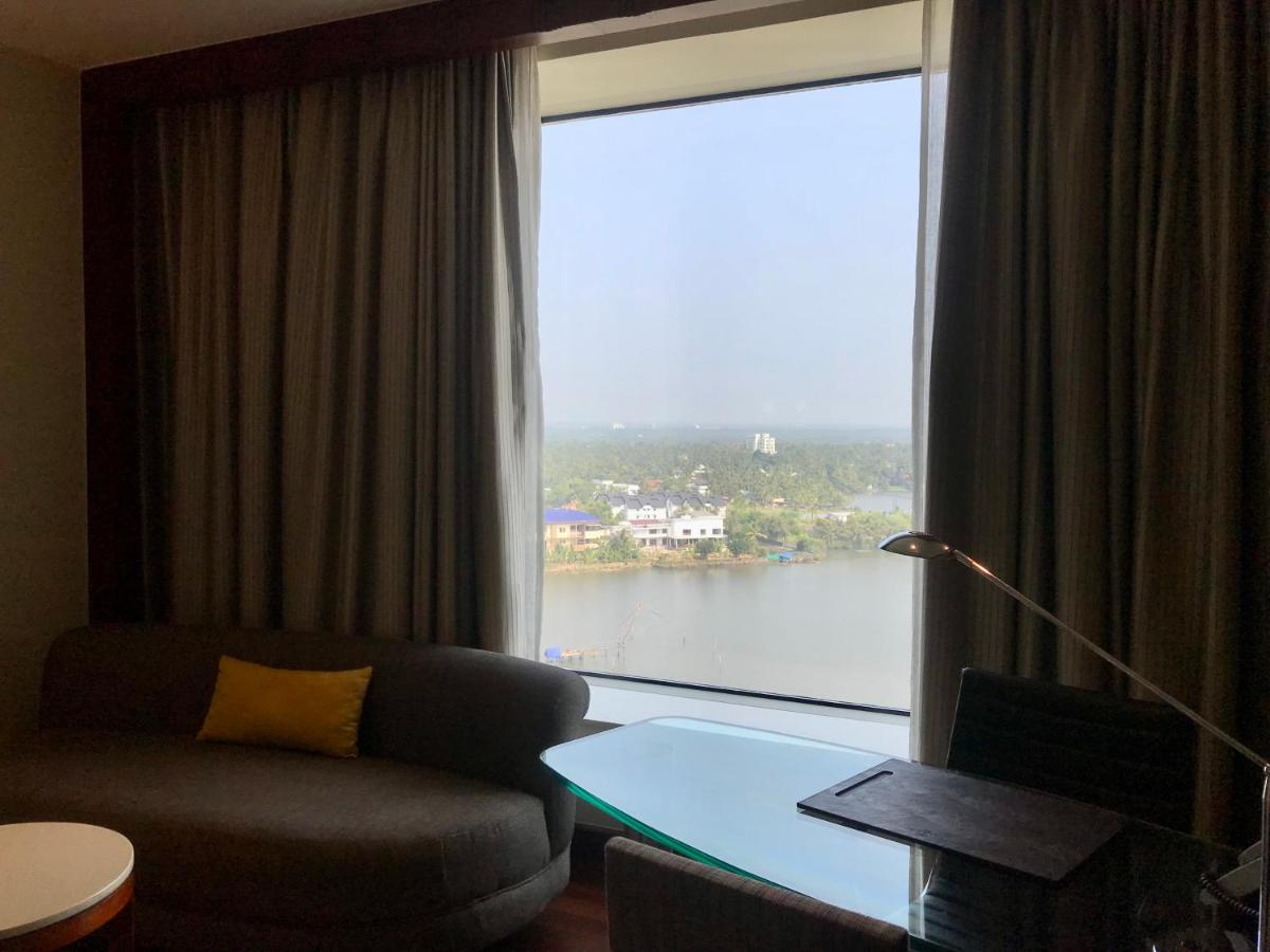 a living room with a couch and a large window at Crowne Plaza Kochi by IHG in Cochin