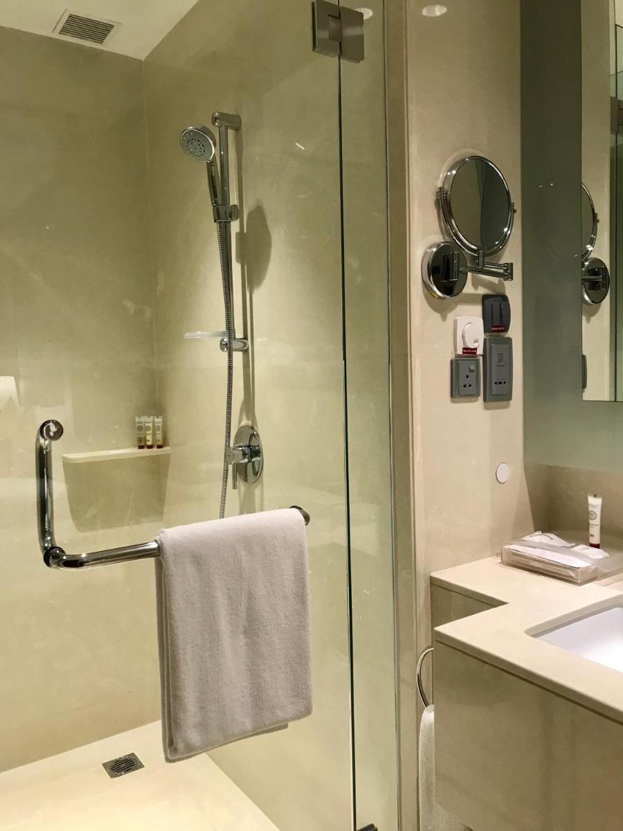 a bathroom with a shower with a towel and a sink at Crowne Plaza Kochi by IHG in Cochin