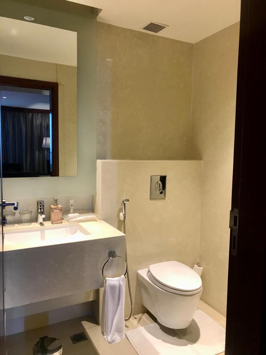 a bathroom with a toilet and a sink at Crowne Plaza Kochi by IHG in Cochin