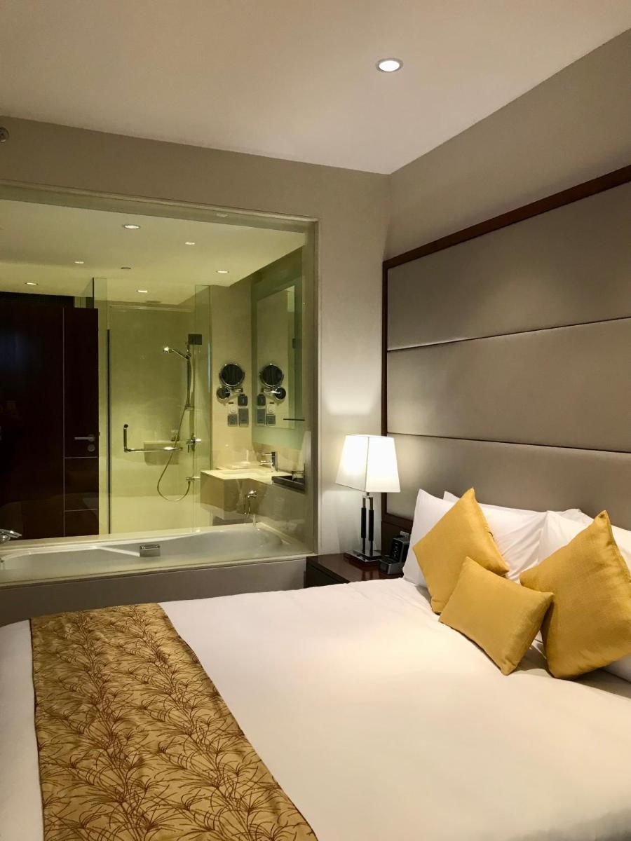 a bedroom with a large bed and a bath tub at Crowne Plaza Kochi by IHG in Cochin
