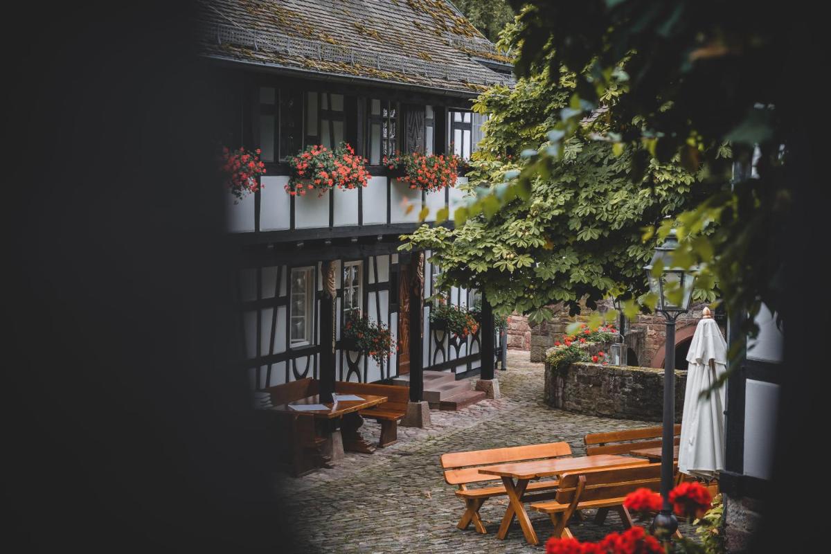 eine Gruppe von Tischen und Bänken vor einem Gebäude in der Unterkunft Neumühle Resort & Spa in Hammelburg