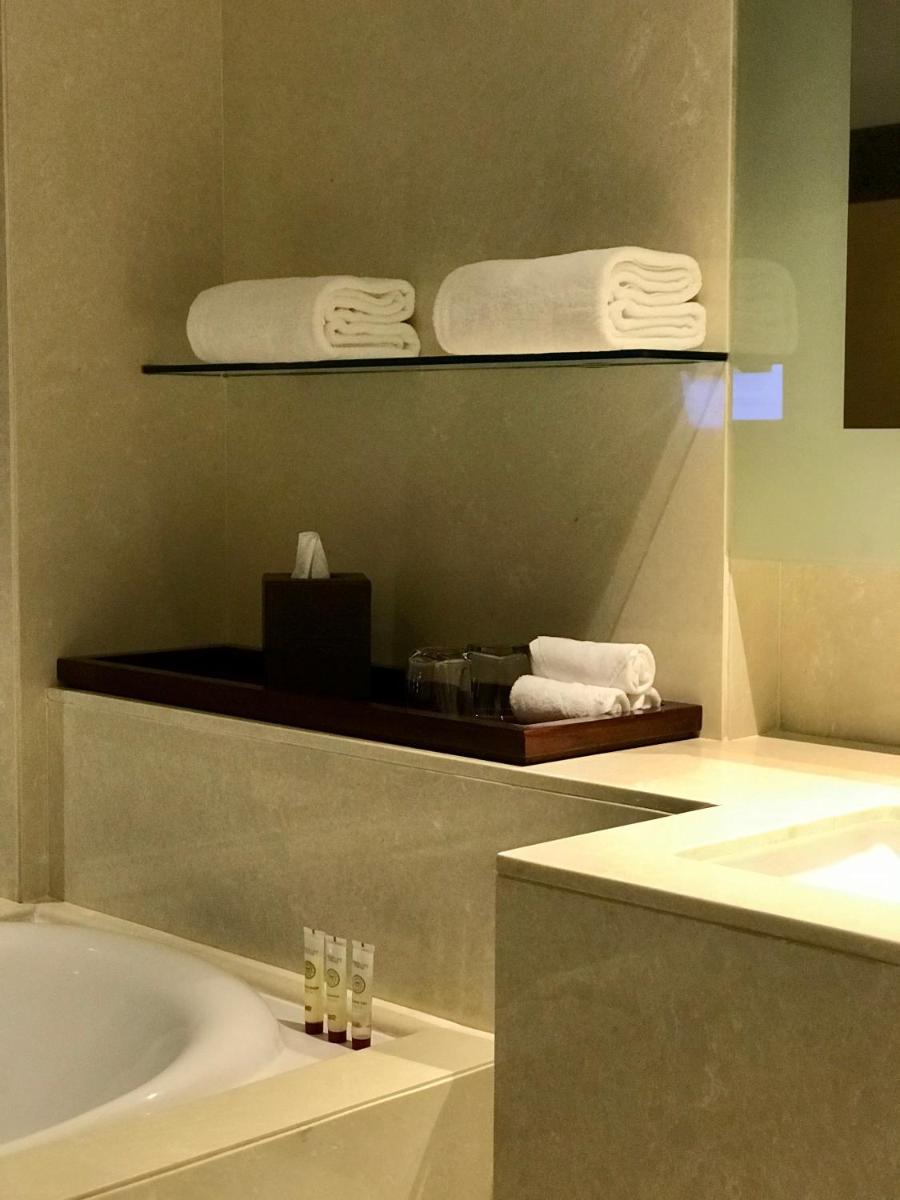 a bathroom with a tub and a sink and towels at Crowne Plaza Kochi by IHG in Cochin