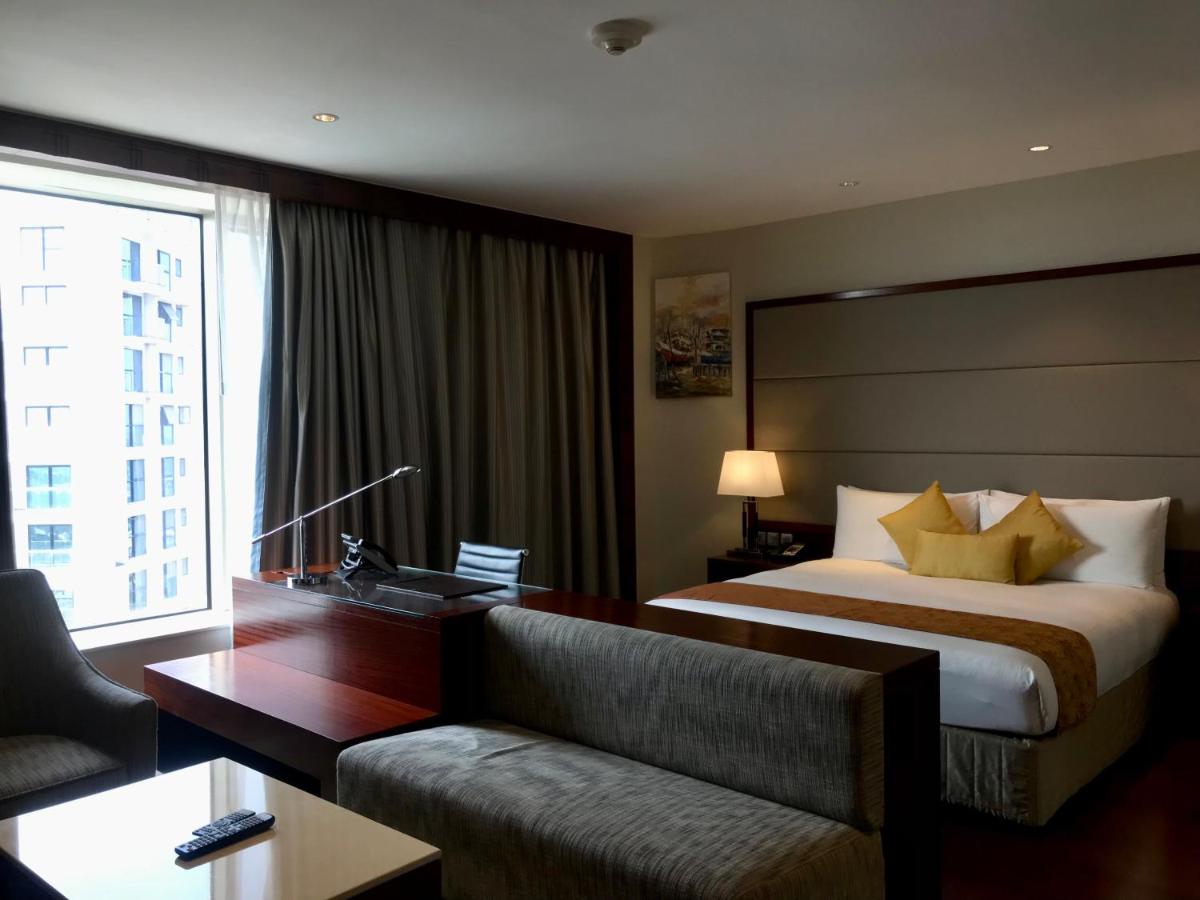a hotel room with a bed and a desk and a couch at Crowne Plaza Kochi by IHG in Cochin