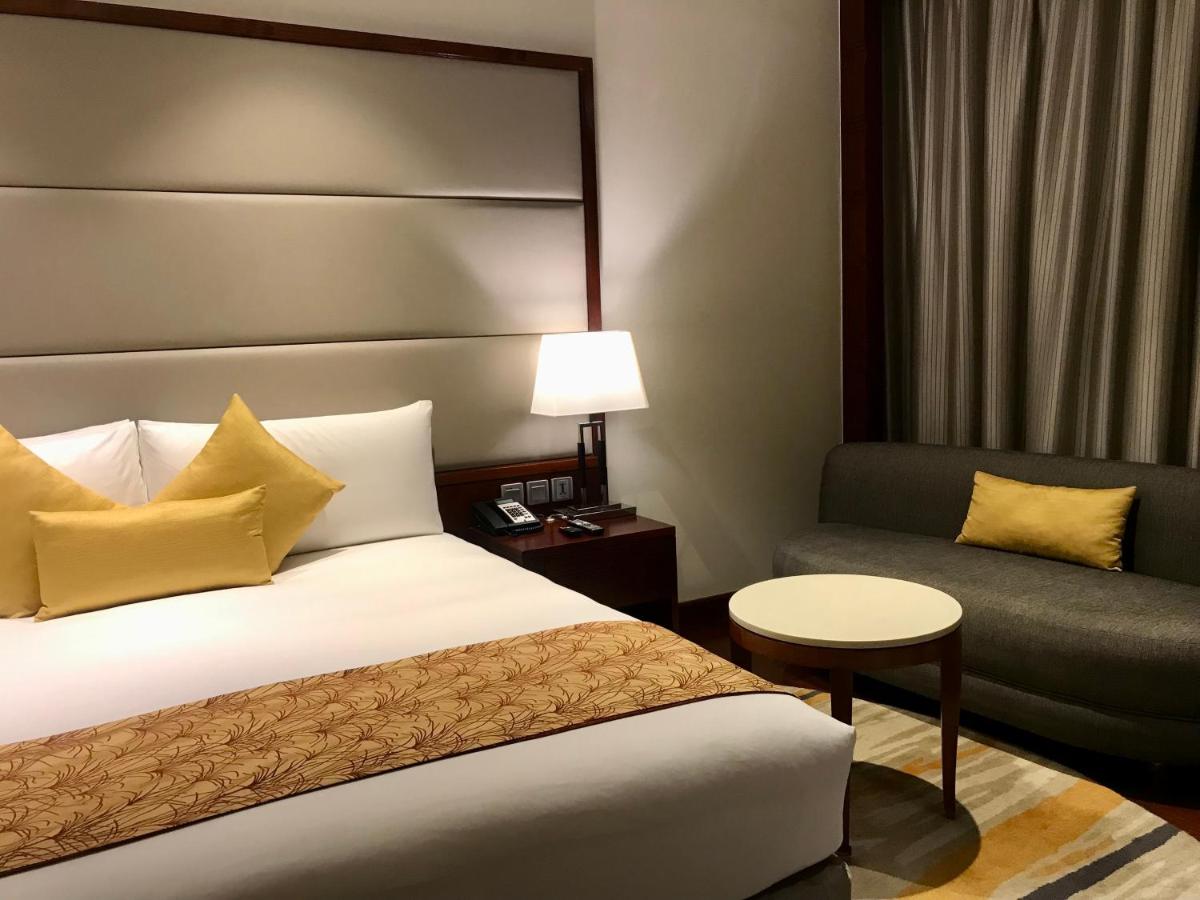 a hotel room with a bed and a chair at Crowne Plaza Kochi by IHG in Cochin
