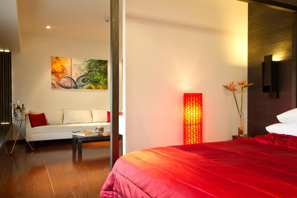 a hotel room with a red bed and a couch at Svenska Design Hotel in Mumbai