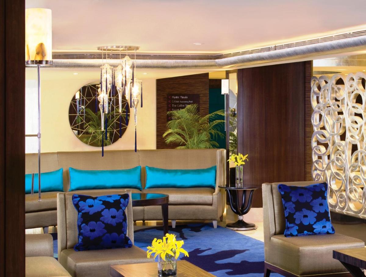 a lobby with chairs and a couch and a chandelier at Blue Diamond Pune IHCL SeleQtions in Pune