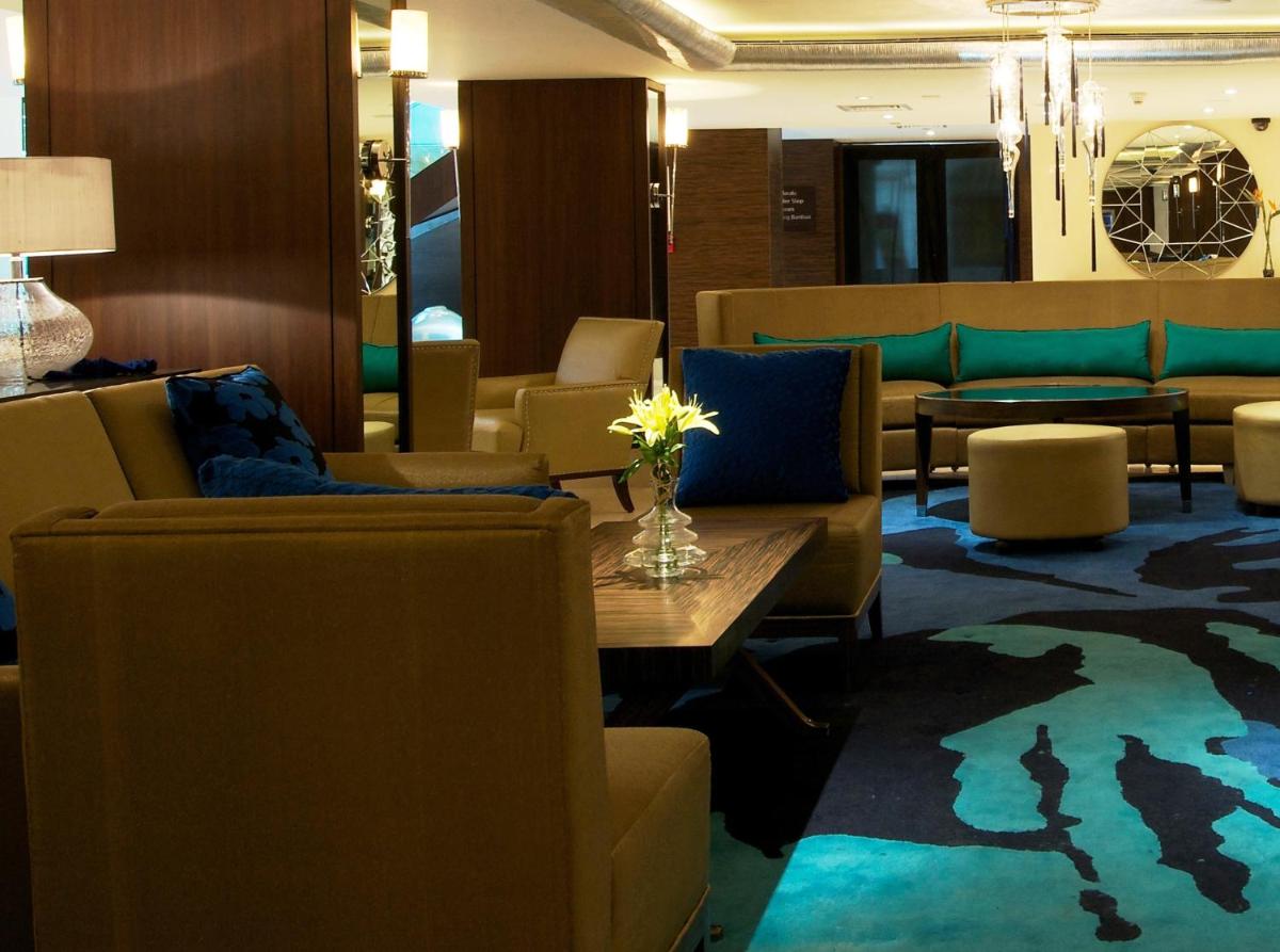 a lobby with couches and a table and chairs at Blue Diamond Pune IHCL SeleQtions in Pune